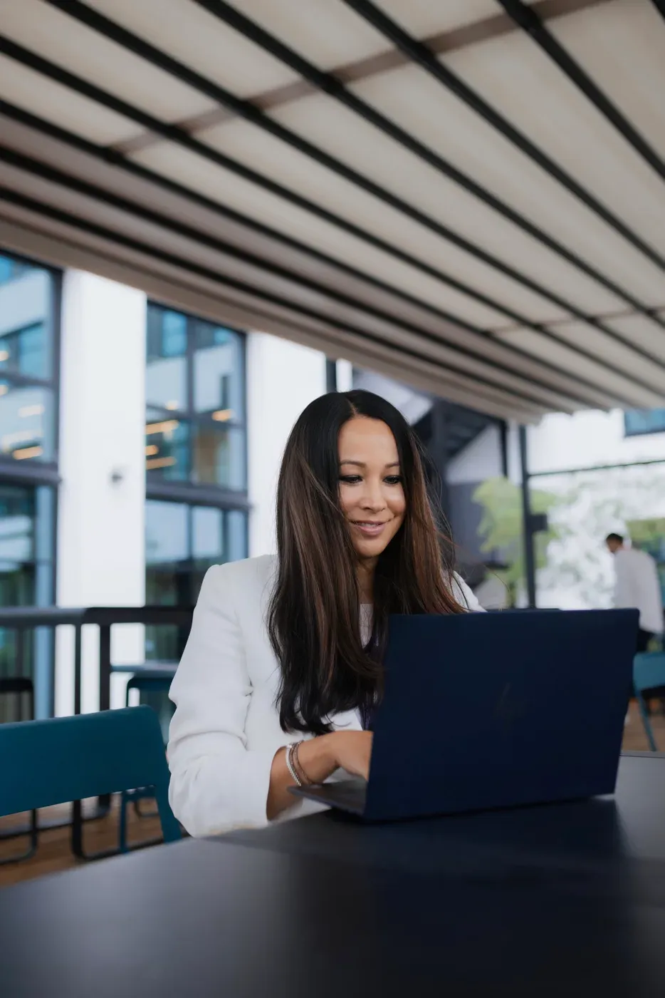 Yasmin Weiß am Laptop in einem lichtdurchfluteten Büro